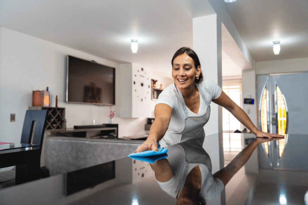 Experienced maid service wiping and sanitizing a kitchen island during a thorough deep cleaning service.